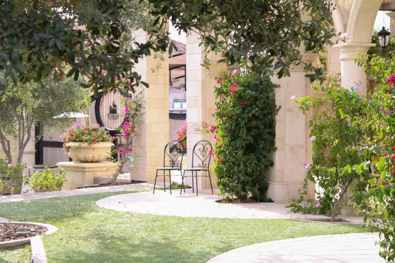 Shaded stone courtyard with bougainvillea and wrought-iron chairs