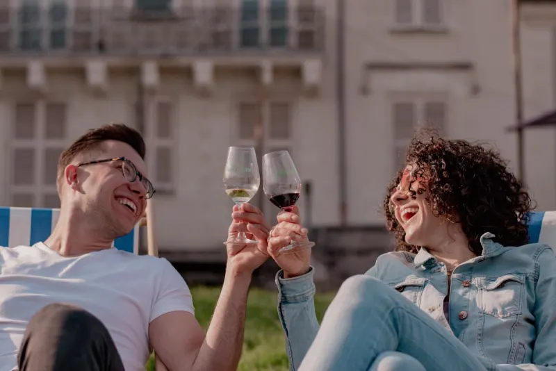 Friends laughing while toasting wine glasses