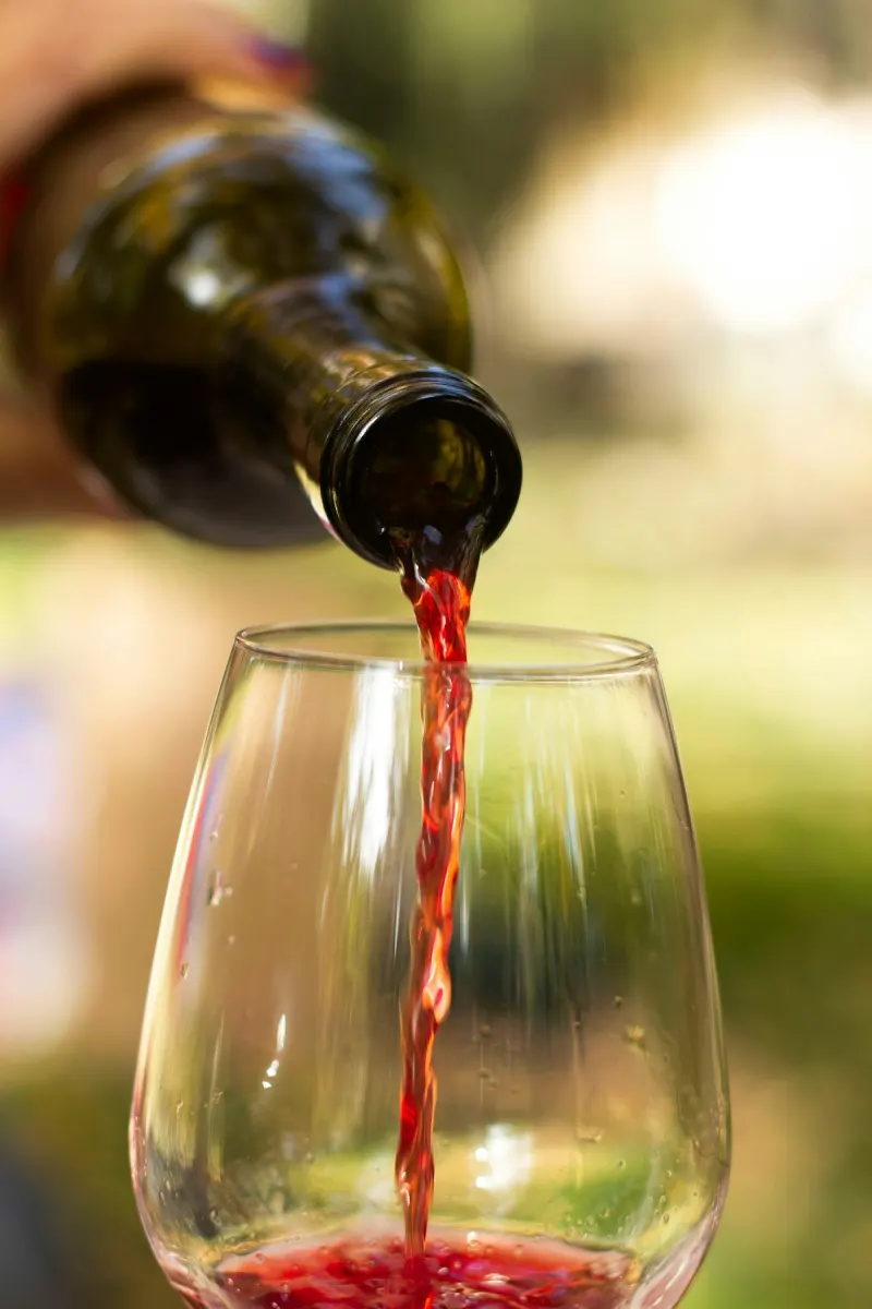 Red wine being poured into a glass outdoors